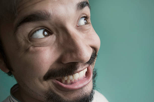 Close up of a happy young man. Close up of a happy young man looking up/sideways. side eye expression stock pictures, royalty-free photos & images
