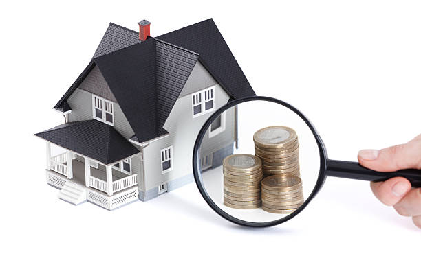 istock Coins in front of house architectural model 177395481
