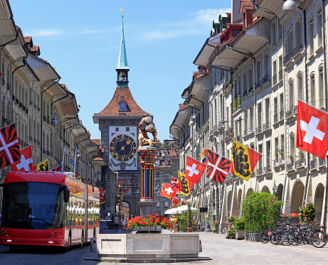 Photo of Lucerne Switzerland showing the Rathaus (city hall) and roof of the famous Kapelbrücke covered bridge located in the historic center of town.