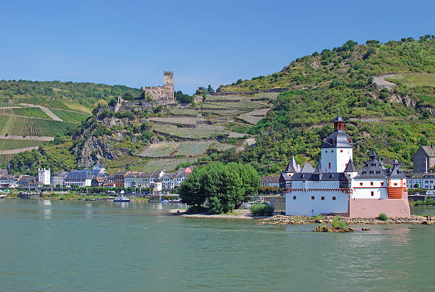Scenic autumn view of Oberwesel on the Rhine with medieval tower, colorful trees, and hillside vineyards