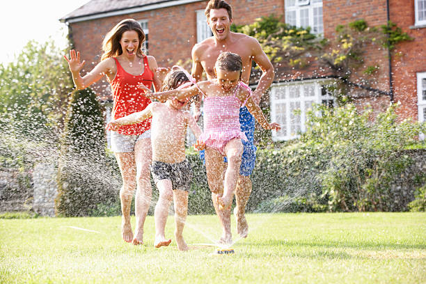 istock Family Running Through Garden Sprinkler 177399587