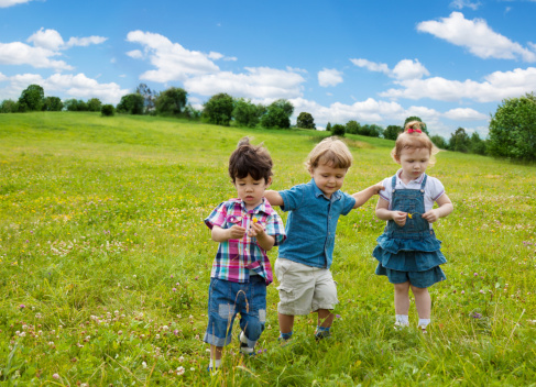 two boys and one girl walking in the park