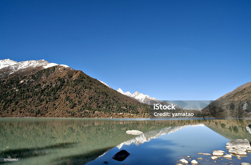 landscape the reflections of the blue sky and snow mountains are mirrored in the beautiful lake . Blue Stock Photo