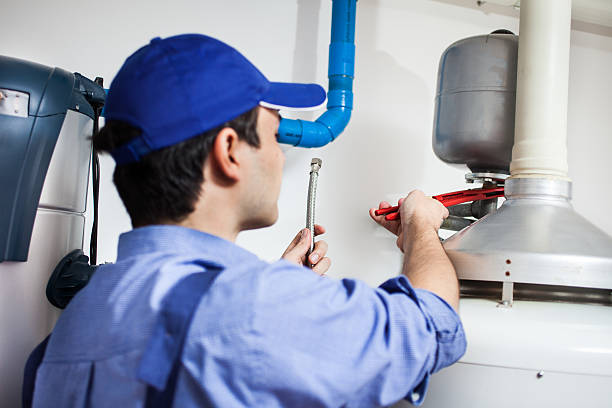 Technician repairing hot water heater stock photo