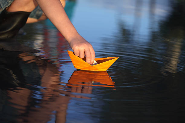 paper ship in children hand