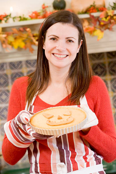 istock Woman in kitchen making Halloween treats and smiling 177401639
