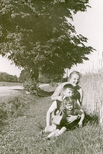 Vintage black and white photo of a smiling mother and her children posing in the sunshine.See my other family photos here: