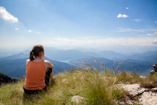 Woman sitting near beautiful blue lake with white sand beach and enjoying its stunning view. Salda Lake, Turkey