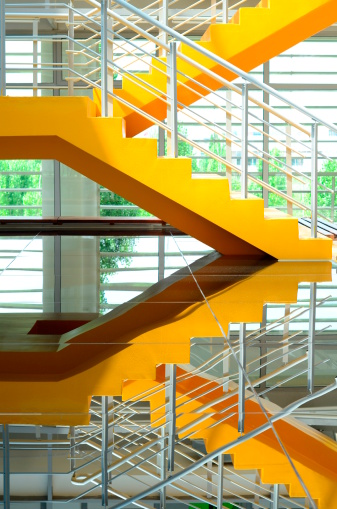 yellow colored stairwell in a modern building (with reflection - nobody in)