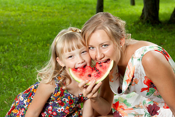 istock mother and daughter eating watermelon 177404045