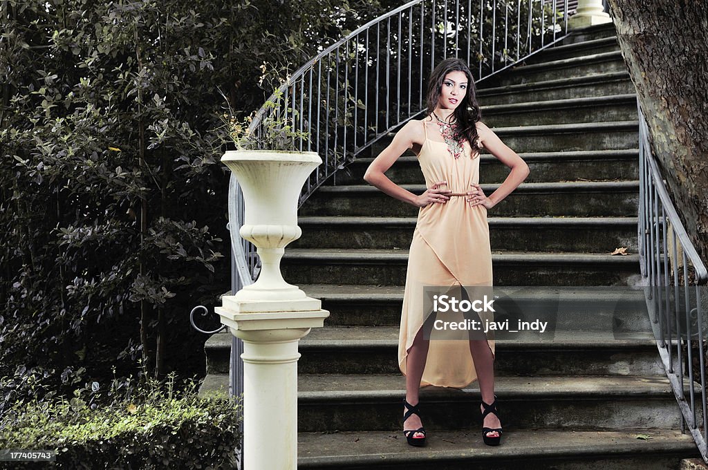Atractiva mujer joven en una escalera al jardín - Foto de stock de Adulto libre de derechos