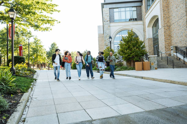Group of diverse Hispanic, American and African students in campus outdoors, walking together and talking