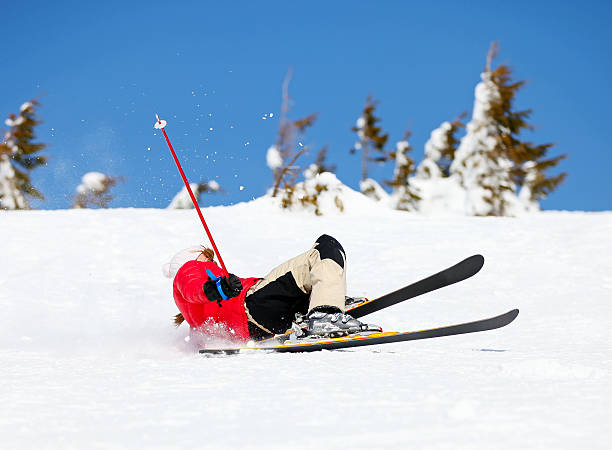 Girl skier falling down on mountain slope stock photo