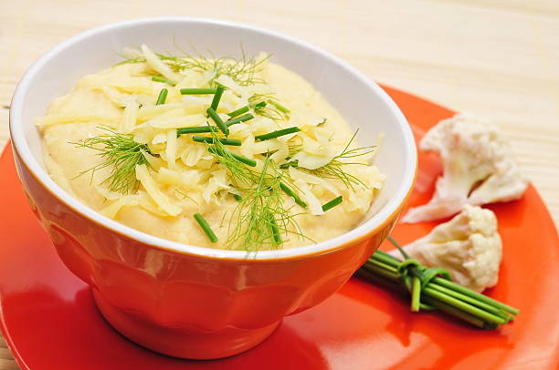 Cauliflower soup in orange bowl