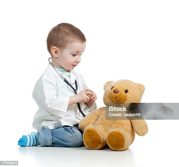 Adorable Child With Clothes Of Doctor Examining Teddy Bear Stock Photo - Download Image Now