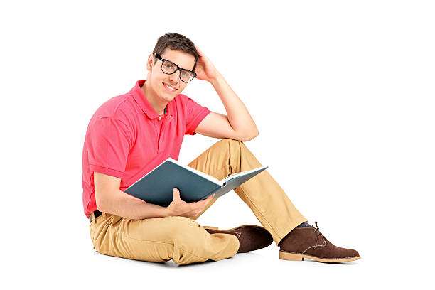 istock Young man sitting on floor and reading a book 177408760