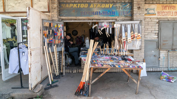 Osh, Kyrgyzstan - May 2022: Local hardware store in Osh's major market in the city center. Two elderly men are seated in an old-looking store.