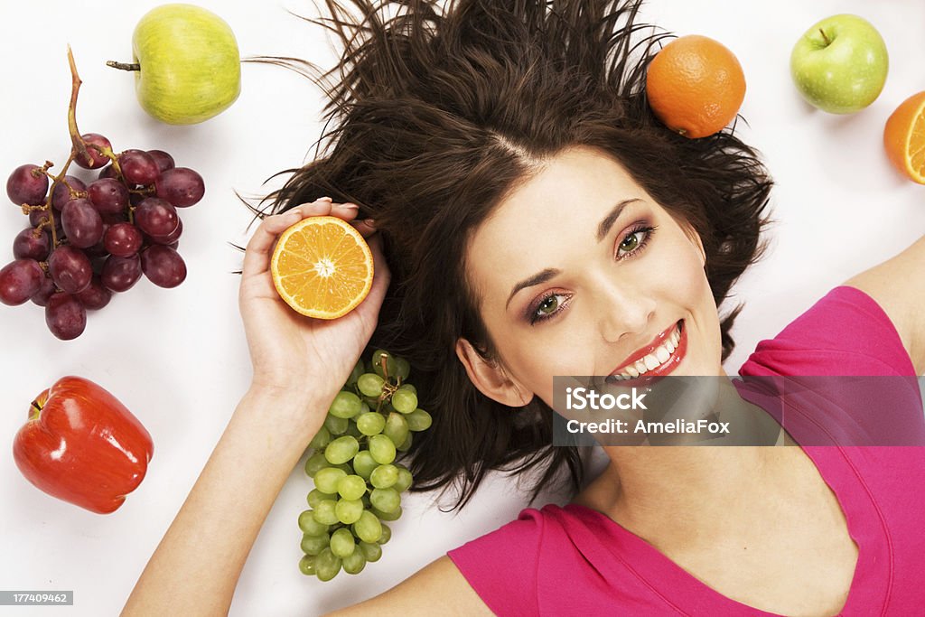 Fruity girl Happy girl lying on the floor enclosed with fruits Adult Stock Photo