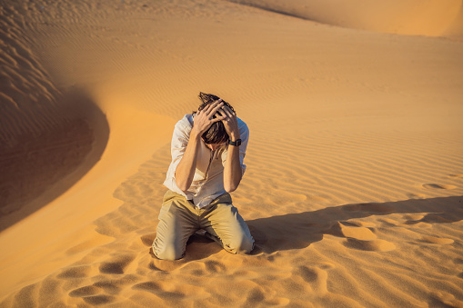 Exhausted man in the desert. Apathy, fatigue, exhaustion, mental disorders concept. Mental health.