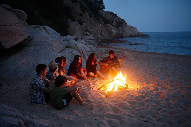 istock teenagers singing around a fire in the beach 177410562
