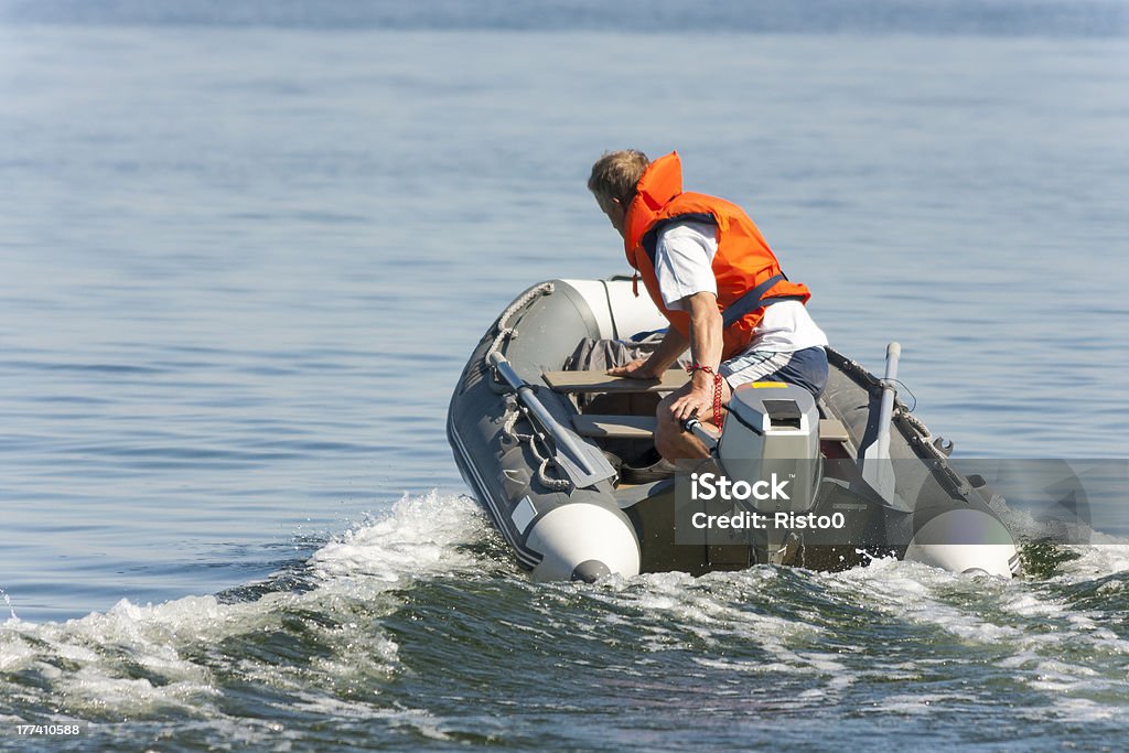 Uomo guida su una barca - Foto stock royalty-free di Mezzo di trasporto marittimo