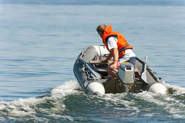 Man riding in an inflatable boat with a motor on sea