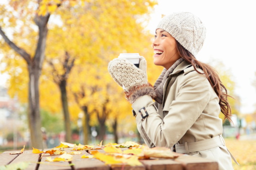 Fall concept - autumn woman drinking coffee