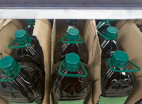 Extra virgin olive oil bottled and displayed on cardboard box at supermarket shelve