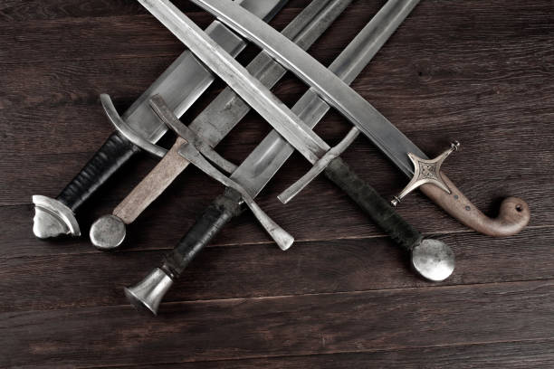 istock Swords and sabre on wooden background. 1774110258