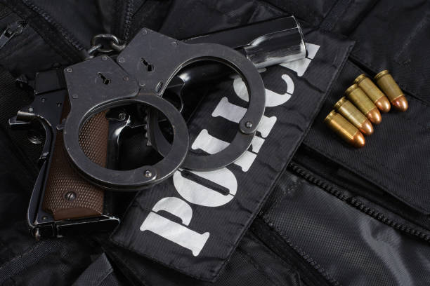 istock Police handgun with handcuffs on black uniform 1774110691