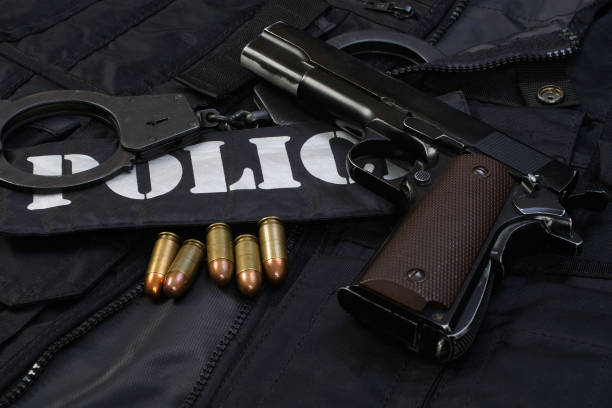 istock Police handgun with handcuffs on black uniform 1774110800