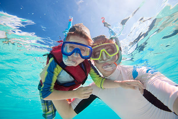 Father and son snorkeling Underwater portrait of father and son snorkeling together scuba diving family stock pictures, royalty-free photos & images