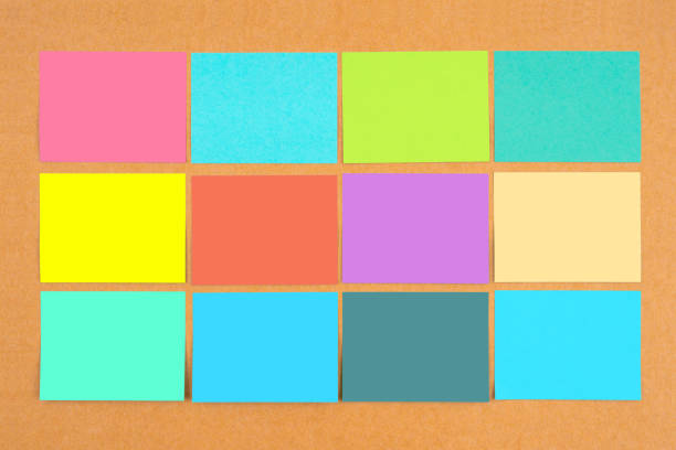 Multicolored of blank sticky notes on wooden board for your text or message.