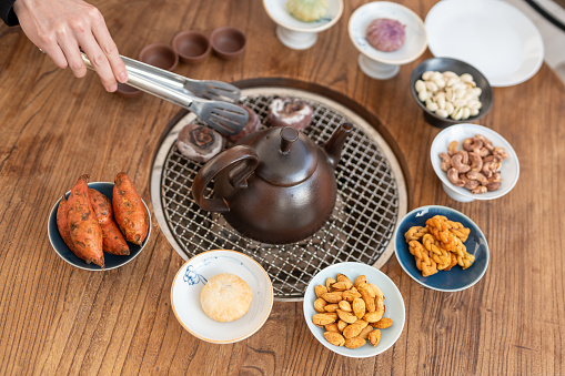 In the Chinese tea art, various fruits and foods are placed around the teapot with charcoal underneath