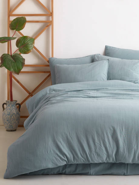 istock Wooden framed comfortable bed with many pillows, blanket 1774142132