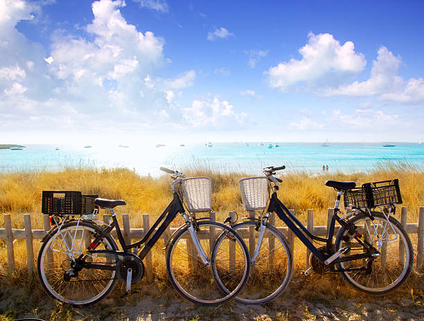 自転車の駐車場 formentera ビーチのカップル - stationary bycicle ストックフォトと画像