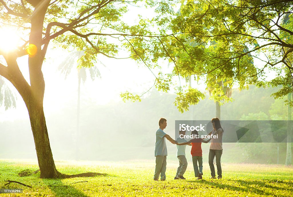 Familia feliz asiática sosteniendo las manos en un círculo - Foto de stock de Familia libre de derechos