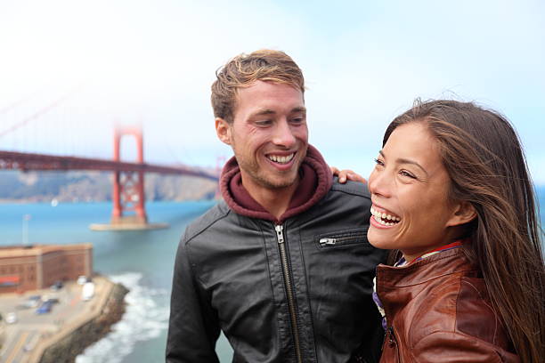 feliz casal jovem rindo, san francisco - golden gate bridge san francisco county cityscape famous place - fotografias e filmes do acervo