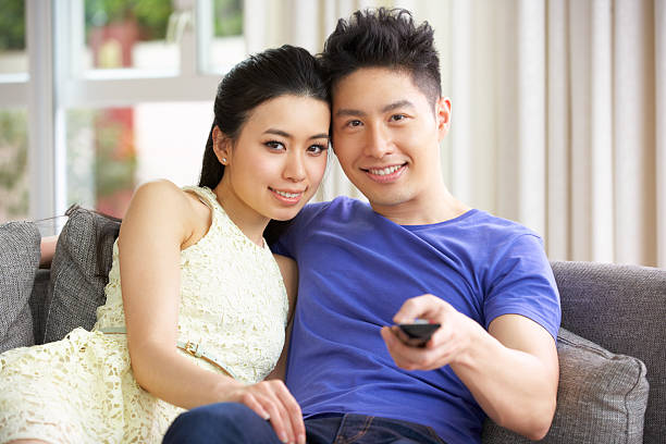 istock Young Chinese Couple Watching TV On Sofa At Home 177414685