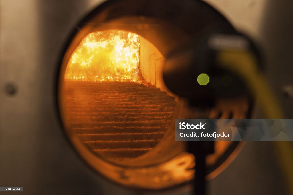 Wood chips in a furnace Wood chips burn in a furnace of co-generation plant Biomass - Renewable Energy Source Stock Photo
