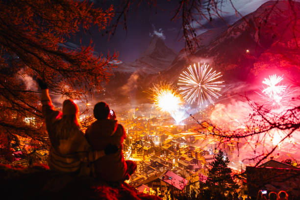 joyful couple celebrating new year outside and looking at the zermatt and matterhorn peak - ski resort winter snow night imagens e fotografias de stock