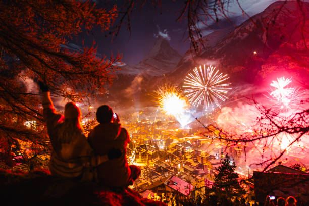 радостная пара празднует новый год на улице и смотрит на вершину церматта и маттерхорна - village switzerland landscape swiss culture стоковые фото и изображения