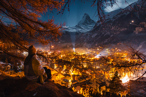 Female tourist enjoying looking over Zermatt and Matterhorn peak at night