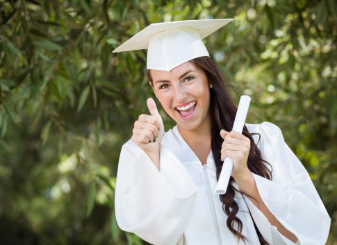 Attractive Mixed Race Girl Celebrating Graduation Outside In Cap and Gown with Diploma in Hand.