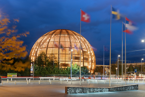 Geneva, Switzerland - October 3, 2023: Traffic passes the Cern Visitor Center at blue hour. The research center operates the largest particle physics laboratory in the world.