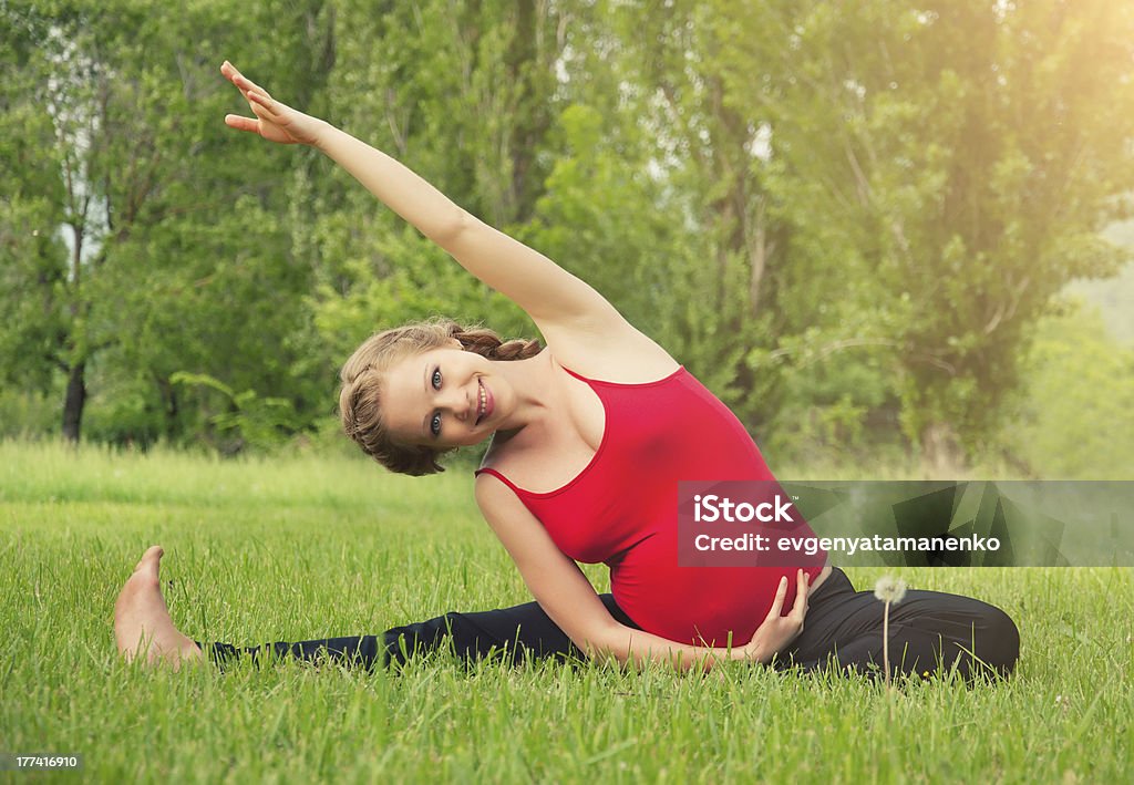 healthy pregnant woman doing yoga in nature healthy pregnant woman doing yoga in nature outdoors Abdomen Stock Photo