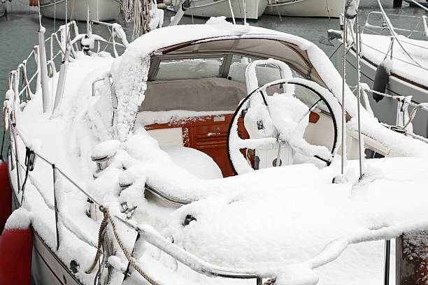 boat with snow in harbor stock photo