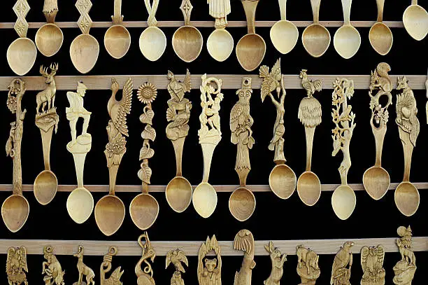Sculpted wooden spoons isolated on black background. Romanian craft art.