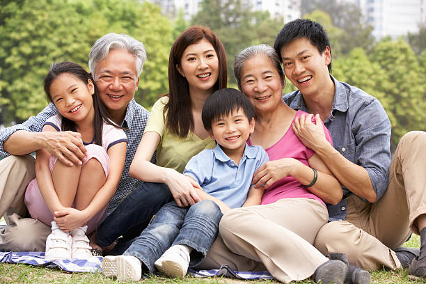 Portrait Of Multi-Generation Chinese Family Relaxing In Park Portrait Of Multi-Generation Chinese Family Relaxing In Park Together Smiling To Camera chinese ethnicity stock pictures, royalty-free photos & images