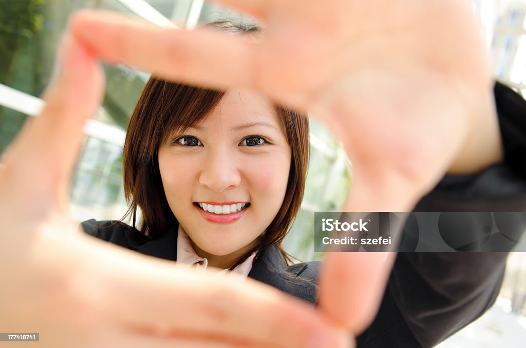 Woman making a box frame with her fingers Smiling Asian business woman making a frame with fingers Finger Frame Stock Photo